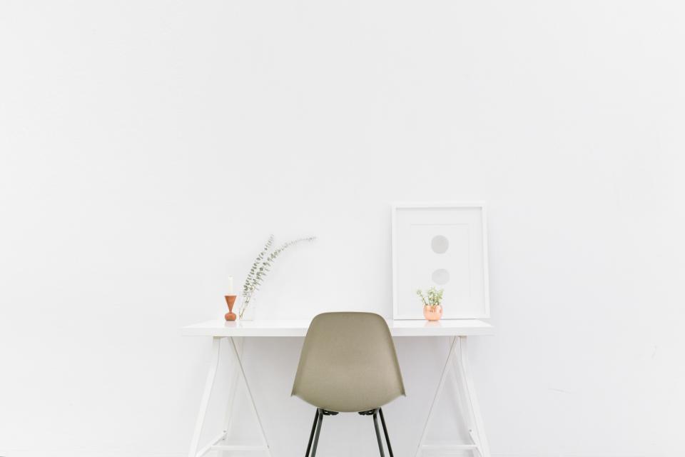 A person working at a desk holding their lower back, the kind of everyday strain that brings people in for chiropractic care